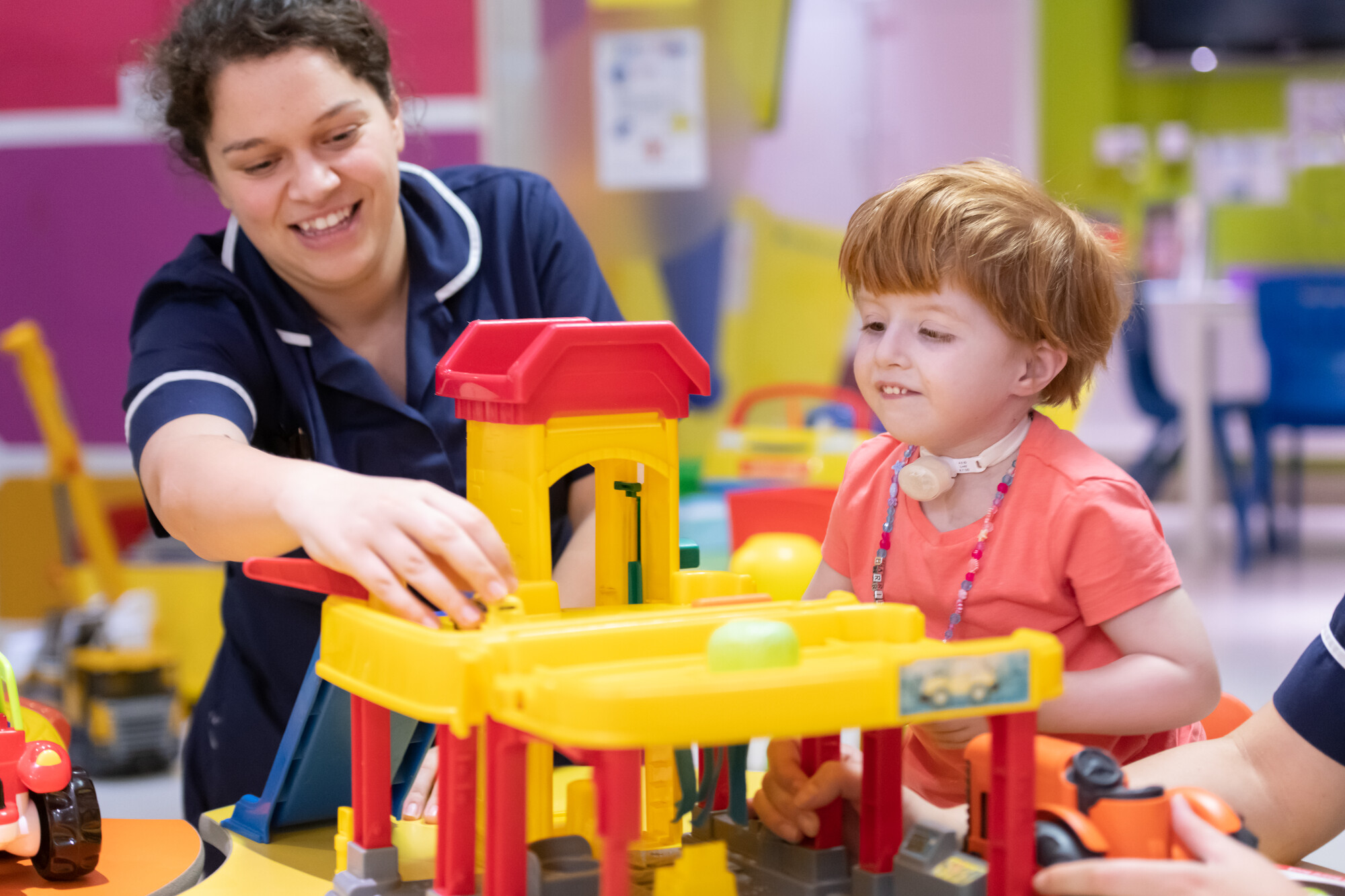 A nurse plays with a young child with red hair in the play room on the children's ward at St Mary's Hospital 